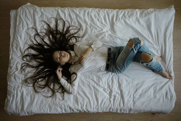 Дівчина-підліток з довгим волоссям у ліжку — стокове фото