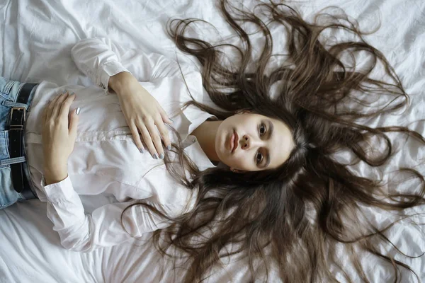 Tonårig flicka med långt hår i sängen — Stockfoto