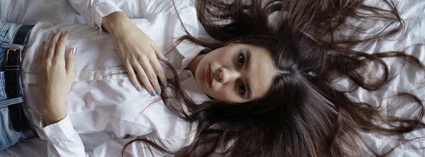 Yatakta uzun saçlı genç kız — Stok fotoğraf