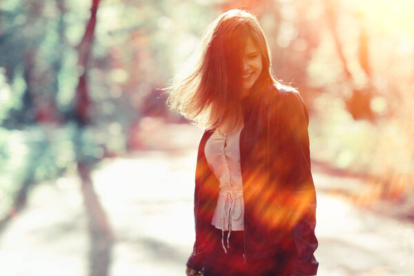 Portrait of young beautiful woman with flying hair in windy weather, sunlight effect