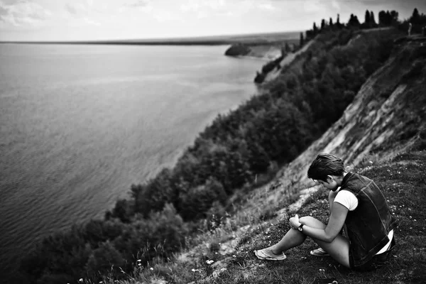 Femme assise au bord de la rivière — Photo