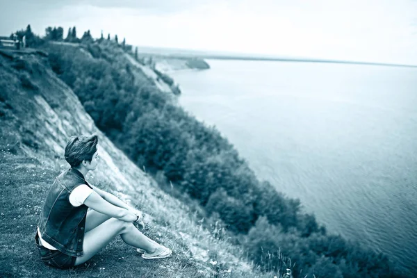 Femme assise au bord de la rivière — Photo