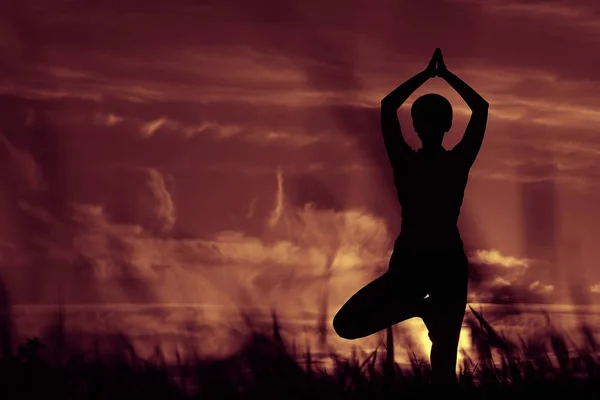 Mujer haciendo yoga contra la puesta del sol cielo —  Fotos de Stock