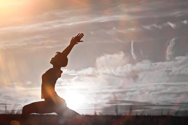 Woman doing yoga against sunset sky — Stock Photo, Image