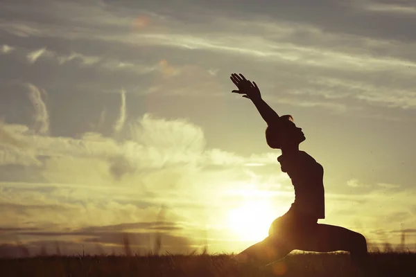 Günbatımı gökyüzü karşı yoga yaparken kadın — Stok fotoğraf