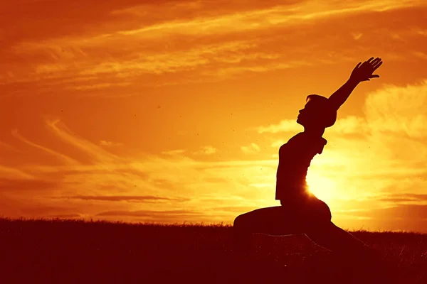 Mujer haciendo yoga contra la puesta del sol cielo —  Fotos de Stock