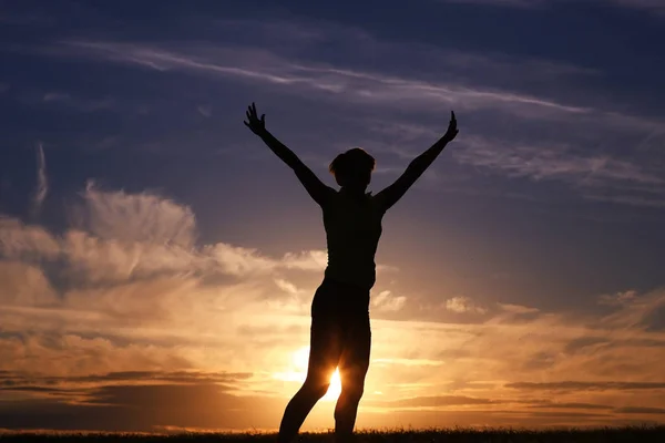 Mujer saltando contra el cielo puesta del sol — Foto de Stock