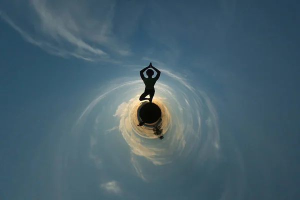Žena, která dělá jógu proti západu slunce na obloze — Stock fotografie