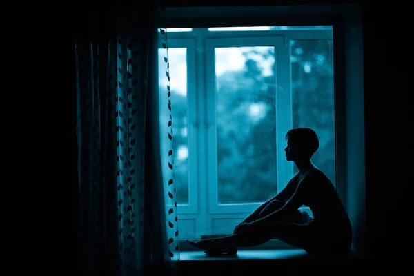 Frau sitzt auf Fensterbank — Stockfoto