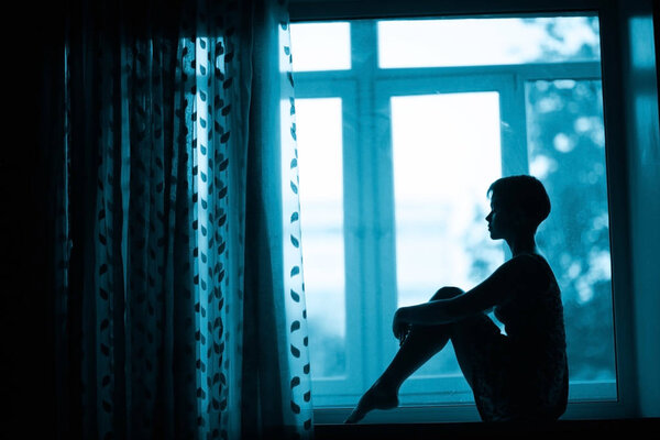 woman sitting on windowsill 