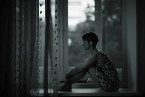 Woman sitting on windowsill — Stock Photo, Image