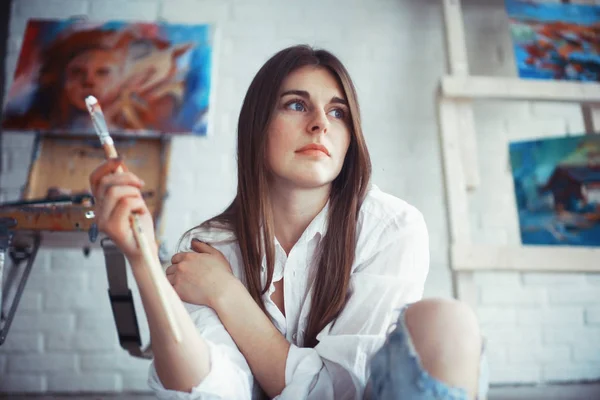 年轻漂亮的女性艺术家 用油漆刷在车间 — 图库照片