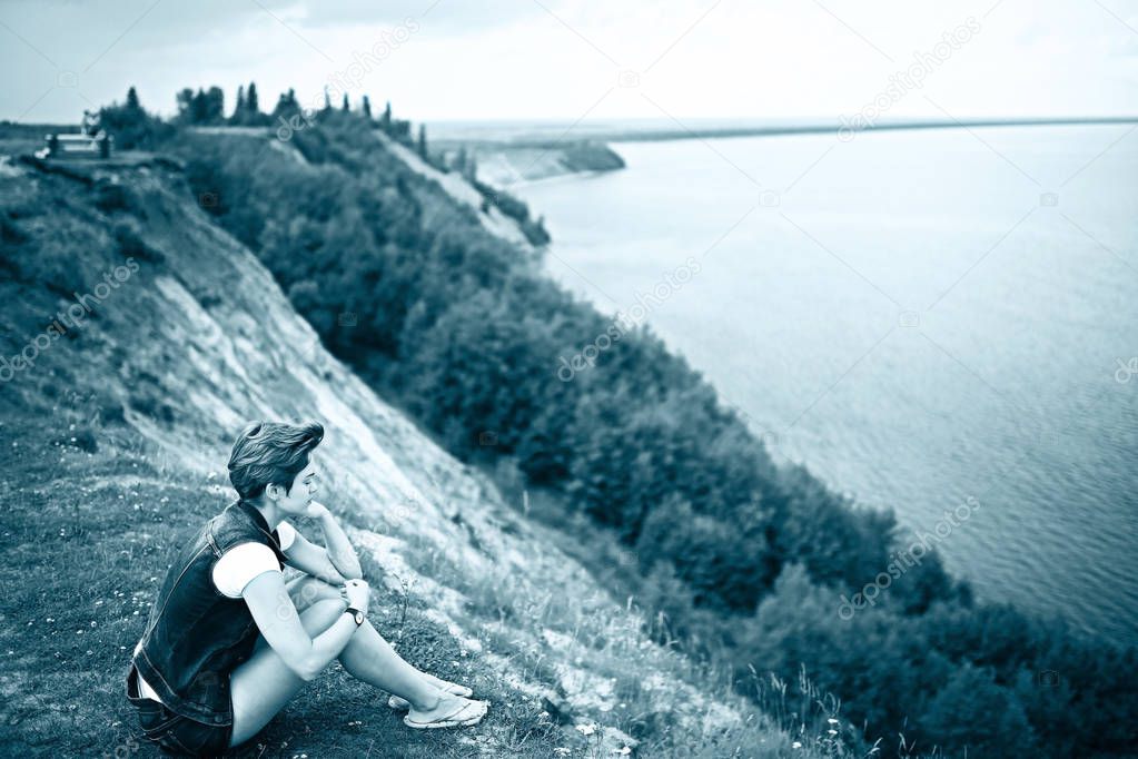 woman sitting at bank of river