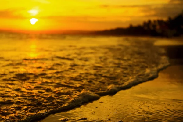 Vågor på stranden vid solnedgången — Stockfoto