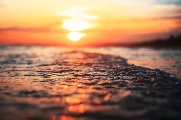 Vågor på stranden vid solnedgången — Stockfoto