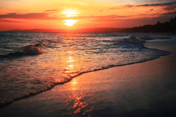 Vågor på stranden vid solnedgången — Stockfoto