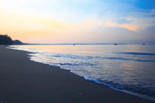 Vagues sur la plage au coucher du soleil — Photo