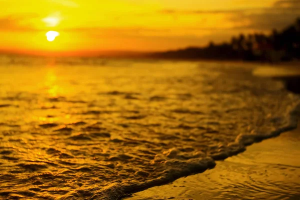 Vagues sur la plage au coucher du soleil — Photo