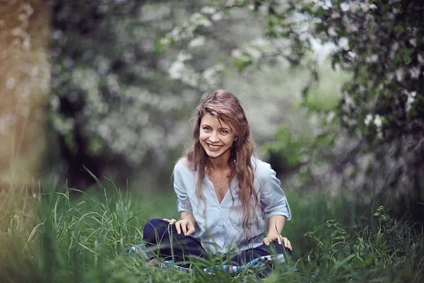 草の上に座っている若い女性 — ストック写真