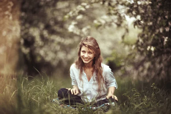 Giovane donna seduta sull'erba — Foto Stock