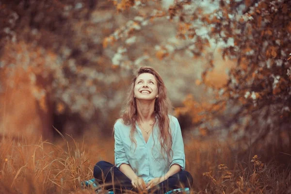 Jonge vrouw zittend op gras — Stockfoto