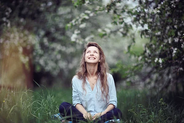 Молодая женщина сидит на траве — стоковое фото
