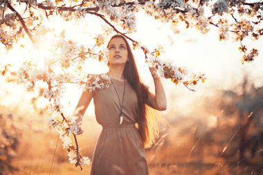 Bahar bahçesinde genç bir kadın 