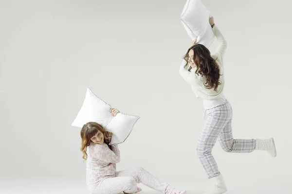 Mujeres jóvenes en pijama luchando con almohadas —  Fotos de Stock