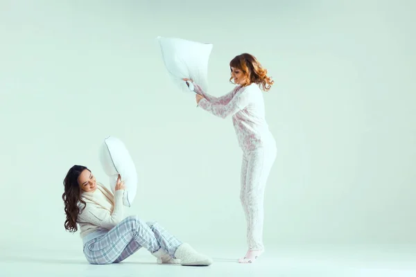 Junge Frauen im Schlafanzug kämpfen mit Kissen — Stockfoto