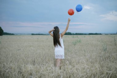 uçan balonlar ile buğday alan kadın