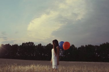 uçan balonlar ile buğday alan kadın