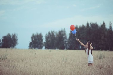 uçan balonlar ile buğday alan kadın