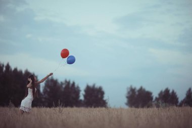 uçan balonlar ile buğday alan kadın