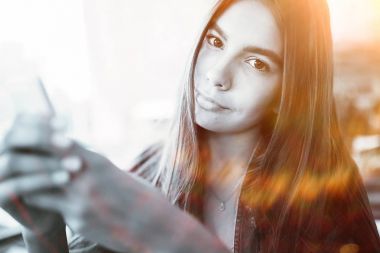 Akıllı telefon kullanan genç bir kadın. 