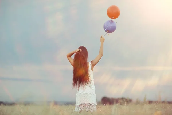 Donna in campo di grano con palloncini volanti — Foto Stock