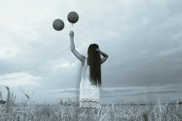 Kobieta w dziedzinie pszenna, latające balony — Zdjęcie stockowe