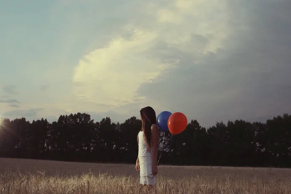 Žena v wheaten poli s létající balóny — Stock fotografie