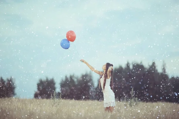 Жінка в пшеничному полі з літаючими кульками — стокове фото
