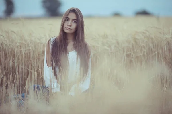 Femme aux cheveux longs dans un champ de blé — Photo