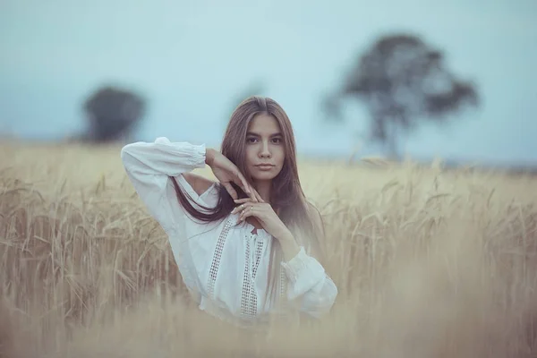 Femme aux cheveux longs dans un champ de blé — Photo