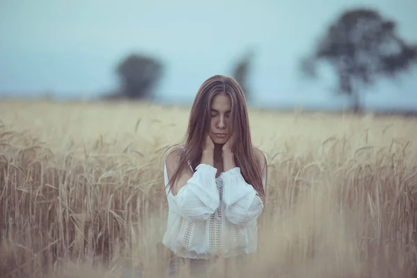Ung kvinna i wheaten fält — Stockfoto