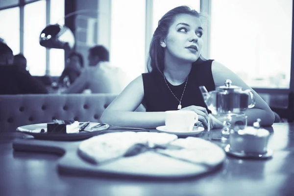 Nuori nainen kahvilassa — kuvapankkivalokuva