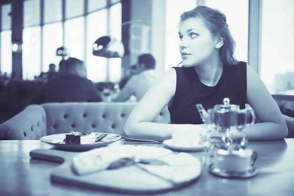 Nuori nainen kahvilassa — kuvapankkivalokuva