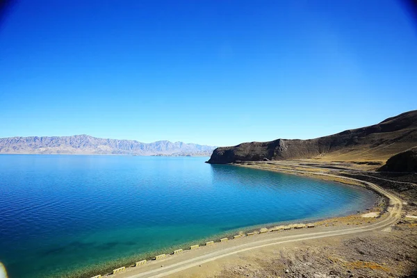 road in Tibetan plateau mountains and blue lake, picturesque landscape