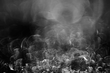 koyu arka plan üzerinde beyaz parlama bokeh ışıklar, sihir efekti yerleşimi.  