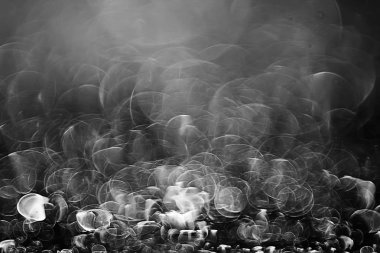 koyu arka plan üzerinde beyaz parlama bokeh ışıklar, sihir efekti yerleşimi.  