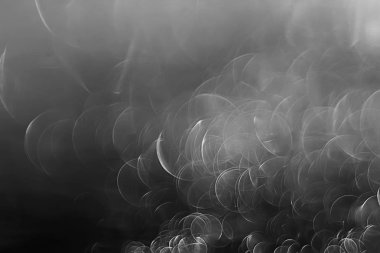 koyu arka plan üzerinde beyaz parlama bokeh ışıklar, sihir efekti yerleşimi.  