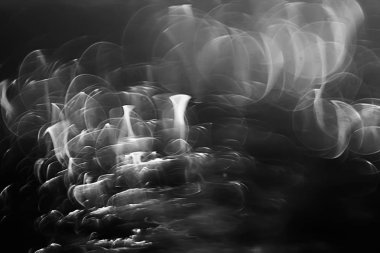 koyu arka plan üzerinde beyaz parlama bokeh ışıklar, sihir efekti yerleşimi.  