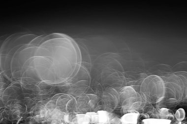 koyu arka plan üzerinde beyaz parlama bokeh ışıklar, sihir efekti yerleşimi.  