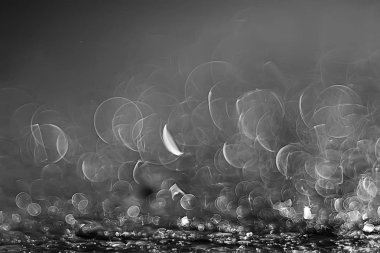 koyu arka plan üzerinde beyaz parlama bokeh ışıklar, sihir efekti yerleşimi.  